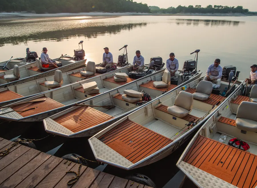 A line of fishing boats at dawn with guides aboard